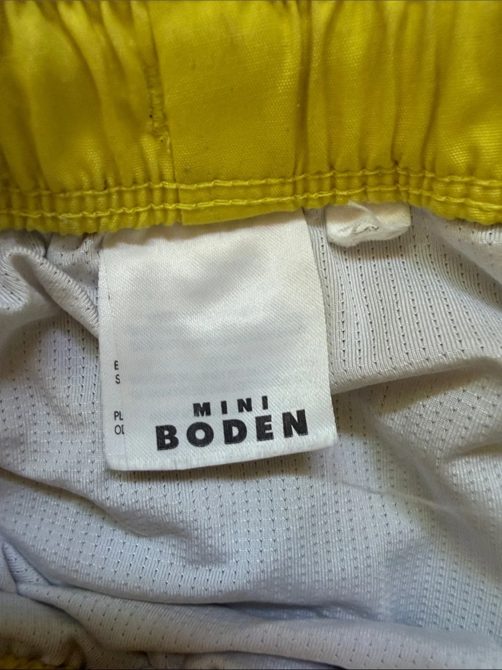 Mini Boden Blue Swim Shorts with Yellow Waistband and Multicolor Ray Print